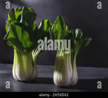 Gesundes frisches Kohl Choy Kohlblätter Blattgemüse auf schwarzem Tisch vor dunklem Hintergrund platziert Stockfoto