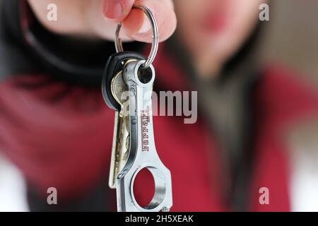Chernigov, Ukraine - 10. Dezember 2012: Der Mann hält die Schlüssel für den Ferrari. Kolben. Autoteile Stockfoto