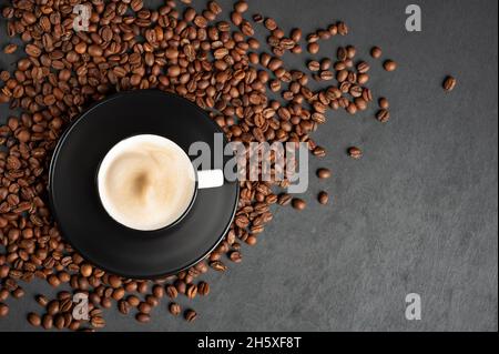 Eine duftende Tasse Kaffee Cappuccino auf einem schwarzen Holzhintergrund. Draufsicht. Speicherplatz kopieren. Stockfoto