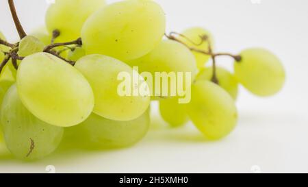 Frische Trauben rotieren auf weißem Hintergrund. Reife saftige Trauben rotieren auf einem Teller. Nahaufnahme eines Bukets weißer Trauben. Stockfoto