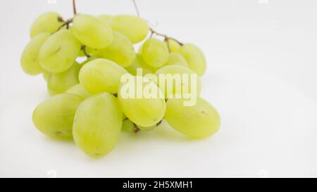 Frische Trauben rotieren auf weißem Hintergrund. Reife saftige Trauben rotieren auf einem Teller. Nahaufnahme eines Bukets weißer Trauben. Stockfoto