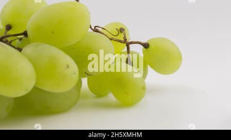 Frische Trauben rotieren auf weißem Hintergrund. Reife saftige Trauben rotieren auf einem Teller. Nahaufnahme eines Bukets weißer Trauben. Stockfoto