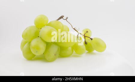 Frische Trauben rotieren auf weißem Hintergrund. Reife saftige Trauben rotieren auf einem Teller. Nahaufnahme eines Bukets weißer Trauben. Stockfoto