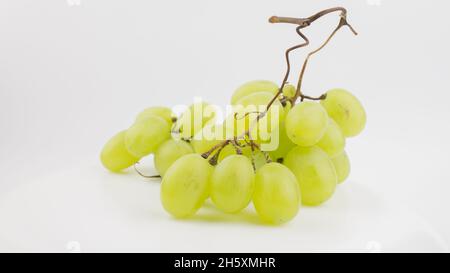 Frische Trauben rotieren auf weißem Hintergrund. Reife saftige Trauben rotieren auf einem Teller. Nahaufnahme eines Bukets weißer Trauben. Stockfoto