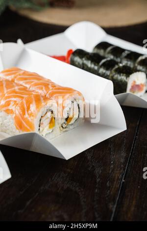 Philadelphia Rolle auf dem Teller für die Lebensmittelzustellung. Rollen Sie mit Lachs, Garnelen und Mango Stockfoto