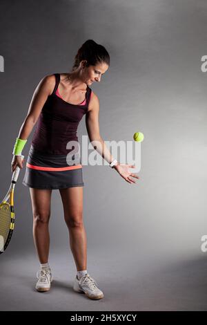 Professionelle Tennisspielerin. Mädchen schwingenden Schläger Vorbereitung zu dienen Stockfoto