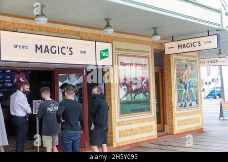 Junge Männer in Australien, die während eines Covid-Ausbruchs Facemarks tragen, checken im Hotel Styeyne Pub in Manly Beach Sydney, Australien, ein Stockfoto