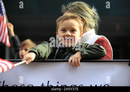 New York, N.Y/USA – 11. November 2021: Ein Kind schwingt während der Veterans Day Parade auf der Fifth Avenue in New York am 11. November 2021 die Flagge der Vereinigten Staaten. Quelle: Gordon Donovan/Alamy Live News) Stockfoto