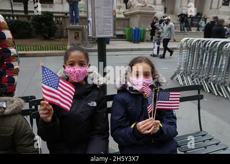 New York, N.Y/USA – 11. November 2021: Ein Kind schwingt während der Veterans Day Parade auf der Fifth Avenue in New York am 11. November 2021 die Flagge der Vereinigten Staaten. Quelle: Gordon Donovan/Alamy Live News) Stockfoto