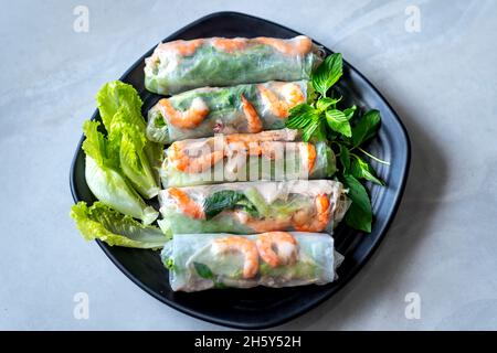 Frische Rolle mit Garnelen im Inneren und Huhn, Tofu, Bohnensprossen, Salat, Minzblatt, Gurke Stockfoto