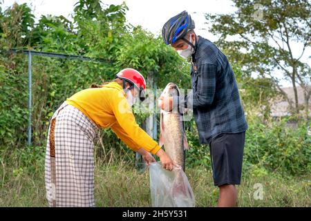 Tri an Hydroelectric Dam, Provinz Dong Nai, Vietnam - 3. November 2021: Ein Paar fängt einen großen Fisch am Tri an Wasserkraftwerk in Dong Nai Provi Stockfoto