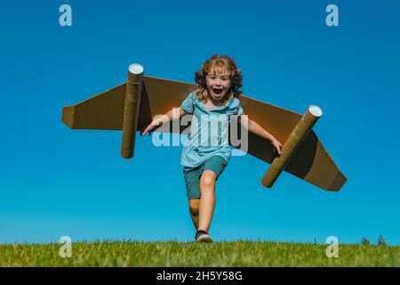 Aufgeregt Kind mit Jet Pack Superhelden. Kinderpilot läuft vor dem Hintergrund des Sommerhimmels. Erfolg, Leader und Sieger Konzept. Fantasie, Freiheit für Kinder. Stockfoto