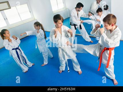 Jugendliche üben neue Karate-Bewegungen paarweise im Unterricht Stockfoto