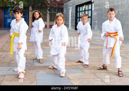 Tweenagers trainieren Karate bewegt sich im Hof der Sportschule Stockfoto