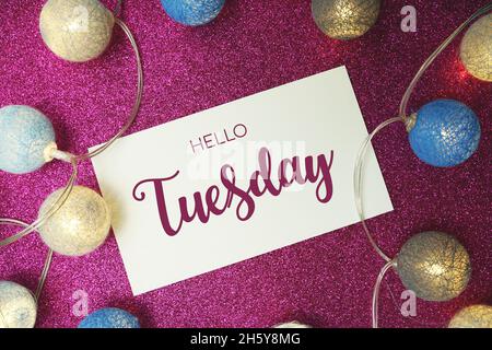 Hallo Dienstag Typografie Text mit LED Baumwollkugel auf rosa Glitzer Hintergrund Stockfoto