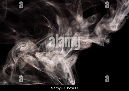 Abstrakte Rauchbewegung auf dunklem Hintergrund. Konzept des alternativen Nikotinrauchens. Verschwommenes Bild warmer, getönter Rauch. Elektronische Zigarette. Verdampfer. Weichfokus. Streaming. Stockfoto