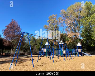 Leerer Kinderspielplatz im Park unter blauem Himmel. Stockfoto