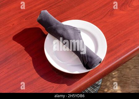 Besteck Serviettenrolle auf weißem Teller. Stockfoto