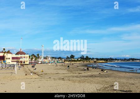 Die Leute genießen den Boardwalk Beach bei Ebbe. Santa Cruz Beach Boardwalk ist im Hintergrund - Santa Cruz, California, USA - 6. November 2021 Stockfoto