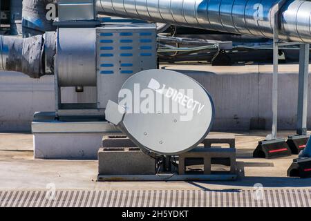 DirecTV-Satellitenantenne mit einem Multi-Satelliten-LNB, der auf dem Gebäudedach installiert ist. DirecTV ist ein amerikanischer Direktübertragungs-Satellitendienst PR Stockfoto