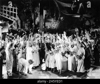 STAN LAUREL und OLIVER HARDY mit FELIX KNIGHT CHARLOTTE HENRY FLORENCE ROBERTS ein Affe als MICKEY-MAUS und die DREI KLEINE SCHWEINE mit Toyland Dorfbewohnern am Set ein ehrliche Gruppenfoto während der Dreharbeiten von BABYS IN TOYLAND aka MARCH OF THE WOODEN SOLDIERS 1934 Regisseure GUS MEINS und CHARLEY ROGERS Musik Victor Herbert Lyrics Glen MacDonough Hal Roach Studios / Metro Goldwyn Mayer Stockfoto