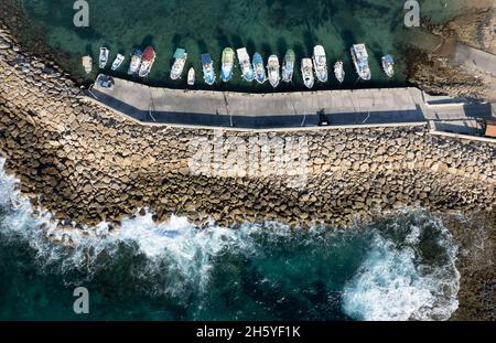 Luftdrohnenansicht von Fischerbooten, die am Hafen festgemacht sind. An Wellenbrechern festgemacht. Stockfoto