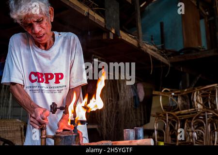 Juli 2017. Rudy Musni stellt Rattanmöbel bei Dagot Rattan Crafts and Furniture her. Puerto Princesa, Palawan, Philippinen Stockfoto