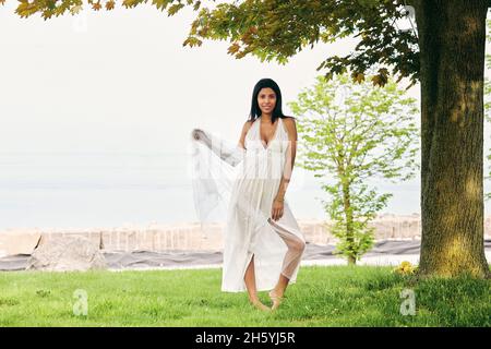 Eine Pause vom Chaos: Dunkelhäutige Latina-Frau findet Trost auf einem Spaziergang am See. Stockfoto