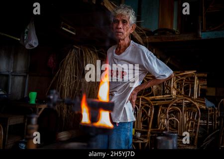 Juli 2017. Rudy Musni stellt Rattanmöbel bei Dagot Rattan Crafts and Furniture her. Puerto Princesa, Palawan, Philippinen. Stockfoto