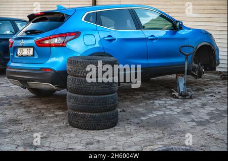 Dobele, Lettland, 9. November 2021:Satz Winterreifen neben dem Auto im Raddienst, das Konzept des saisonalen Reifenwechsels Stockfoto