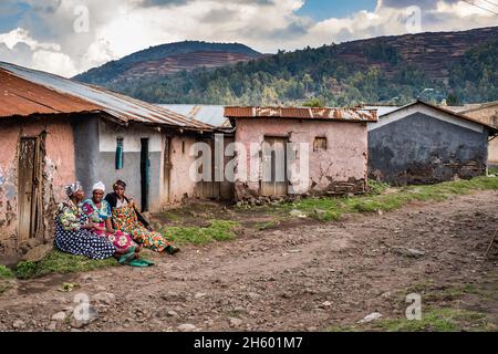 September 2017. Straßenszene in Mwanjari. In der Nähe von Kisoro, Uganda, sitzen Frauen auf der linken Bildseite Stockfoto