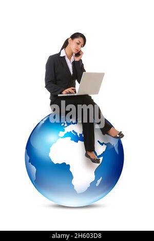 Eine Mitarbeiterin im Unternehmen, die am Laptop arbeitet und am Telefon sitzt und auf grafischer Erde sitzt. Stockfoto