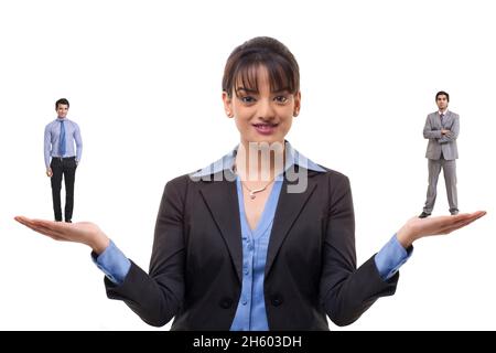 Eine Frau in formellem Geschäftsanzug, die männliche Mitarbeiter in beiden Händen hält. Stockfoto