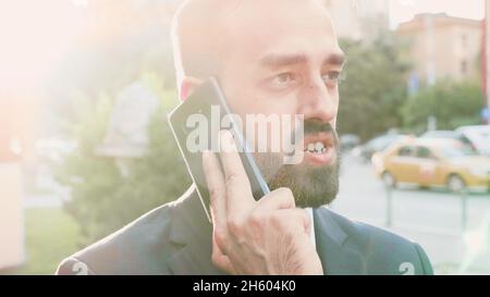 Porträt des Unternehmers Mann in Anzug Gespräch am Telefon Gespräch Management-Projekt mit Remote-Manager Planung Unternehmensstrategie. Geschäftsmann, der vor dem Büro steht. Outdoor-Konzept Stockfoto