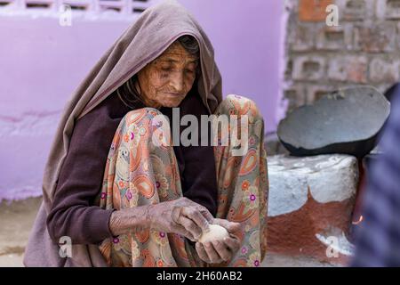 Eine indische Frau im hohen Alter, die in rajasthan, indien, Lebensmittel für die Familie macht Stockfoto