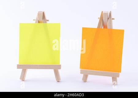 Zwei hölzerne Easels Miniature mit blanker quadratischer Leinwand oder Memopapier - Mockup. Mini-Holzständer mit sauberer Zeichenfläche auf weißem Hintergrund, Copy Space Stockfoto