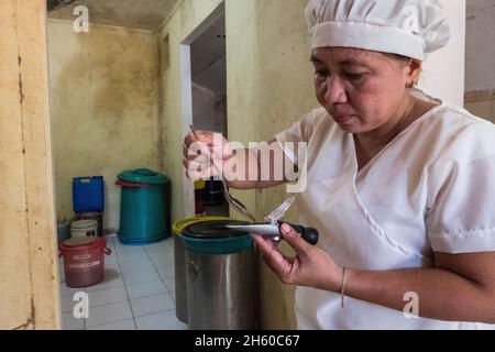 Juli 2017. Melinda Bacani, Mitarbeiter des Nagkakaisang Tribu ng Palawan (NATRIPAL) oder der Vereinigten Stämme von Palawan, verarbeitet und verpackt Rohhonig im Nagkakaisang Tribu ng Palawan (NATRIPAL) oder in den Büros der Vereinigten Stämme von Palawan. Puerto Princesa, Palawan, Philippinen. Stockfoto