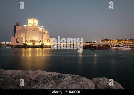 Museum für Islamische Kunst in Doha, Katar Außenaufnahme der Nacht zeigt die einzigartige Architektur des beleuchteten Museums mit Daus im arabischen Golf