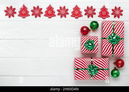 Geschenke in festlicher Verpackung. Weihnachtsrahmen mit Dekorationen, festliche Grußkarte, minimalistisches Design. Für Text platzieren. Vorlage mit Kopierbereich. Flach Stockfoto