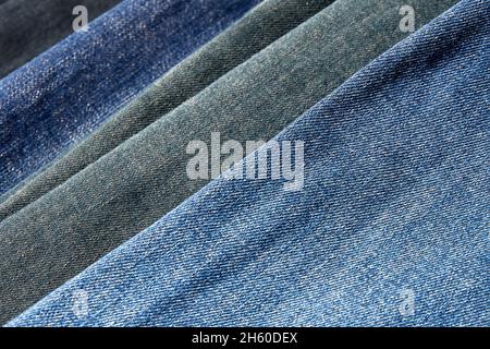 Ein Stapel verschiedener Jeans im Bekleidungsgeschäft. Hintergründe und Texturen Stockfoto