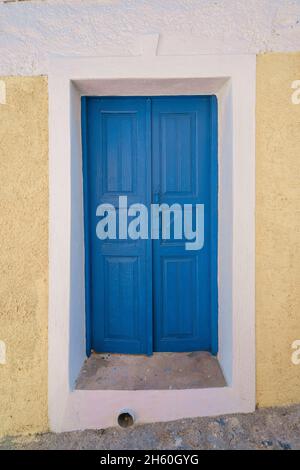 Blaue Holztüren und Wandhintergründe traditioneller griechischer Inselgebäude Stockfoto