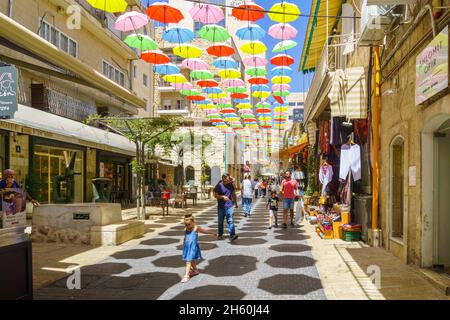 Jerusalem, Israel - 30. August 2021: Fußgänger und bunte Regenschirme (Sonnenschirme), in der Yoel Moshe Solomon Street, dem historischen Nachalat Shiva Nachbarn Stockfoto