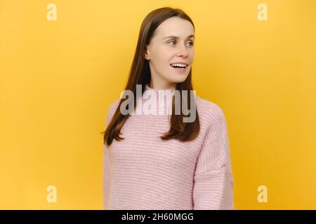 Lächelnd überrascht wunderte sich die Studentin hübsch hübsch hübsch attraktiv Millennial weiblich trägt rosa gestrickt Pullover, schockiert Blick beiseite Stockfoto
