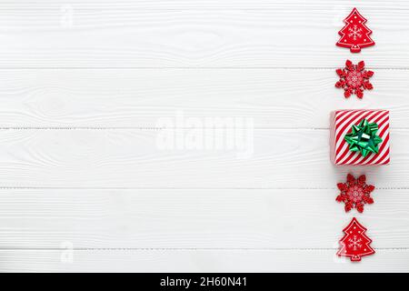 Weihnachts-Grußkarte mit minimalistisches Design. Neujahr Hintergrund mit Dekorationen. Geschenk in festlicher Verpackung. Für Text platzieren. Vorlage mit Kopierbereich Stockfoto