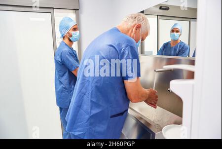 Zwei Chirurgen waschen sich vor einer Operation im Krankenhaus die Hände zur Desinfektion Stockfoto