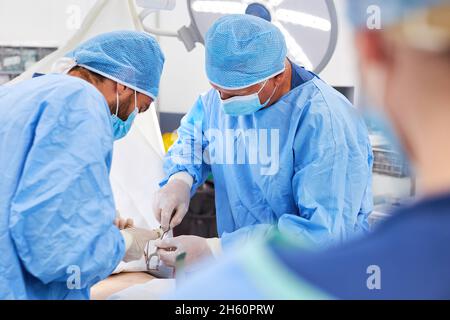 Das Team der Operationsärzte arbeitet während einer Operation in der Klinik für Unfallchirurgie zusammen Stockfoto