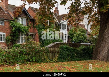 STRATFORD-UPON-AVON, GROSSBRITANNIEN - 15. SEPTEMBER 2014: Dies sind die mit Weinreben bedeckten Hinterhöfe typischer englischer kleiner Häuser an einem Herbstabend. Stockfoto