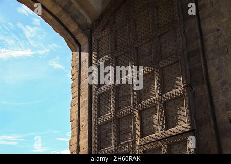 Nahaufnahme der beeindruckenden Porta Romana - Römisches Tor - in Florenz - Florenz - mit riesigen original massiven, eisernen Türen. Blauer Himmel Hintergrund. Stockfoto