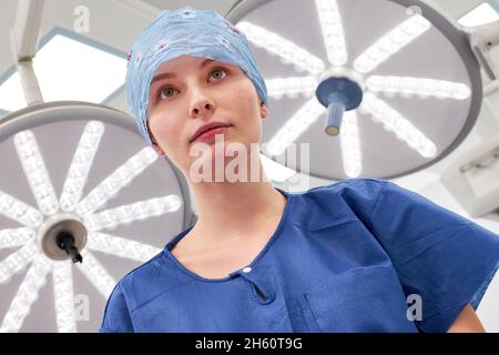 Junge Frau als chirurgische Krankenschwester in der Ausbildung oder Ärztin in einem Praktikum im Operationssaal Stockfoto