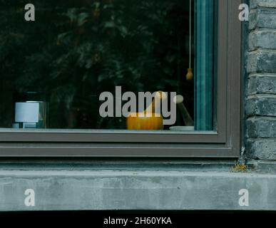 Ein Glasfenster auf dem Campus mit Mauern, die um ihn gewickelt sind. Im Inneren befinden sich Gläser und andere Gegenstände. Sie können durch das Glas sehen. Stockfoto